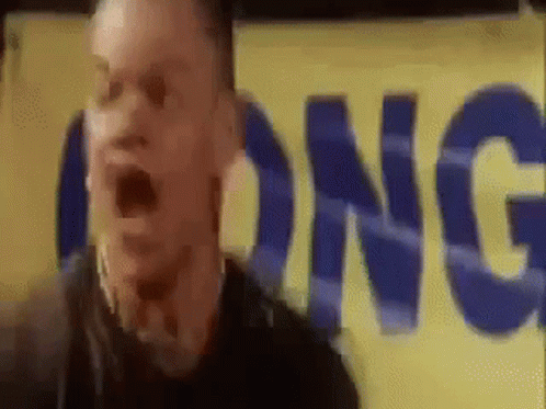 A Man Is Standing In Front Of A Yellow Sign That Says Long GIF