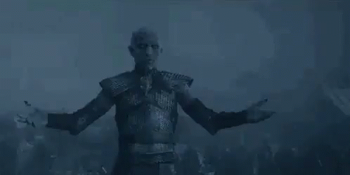A Man Is Standing In The Dark With His Arms Outstretched . GIF