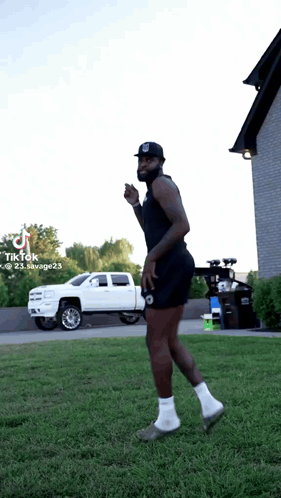 A Man Is Standing In The Grass With A White Truck In The Background And A Tiktok Watermark On The Bottom Right GIF