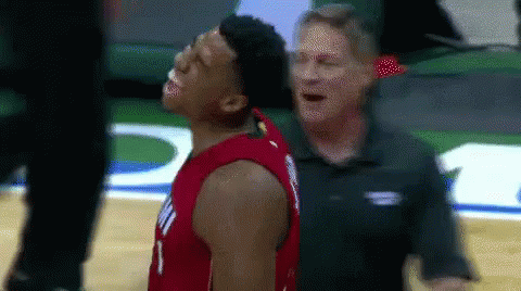 A Man Is Standing Next To A Basketball Player Who Is Looking Up At The Sky . GIF