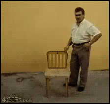 A Man Is Standing Next To A Chair With A 4Gifs.com Watermark On The Bottom Right GIF