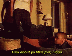 A Man Is Standing Next To A Little Boy Who Is Laying On A Couch And Says " Fuck About Yo Little Fort Nigga " GIF