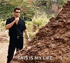 A Man Is Standing Next To A Pile Of Dirt And Talking To Himself . GIF
