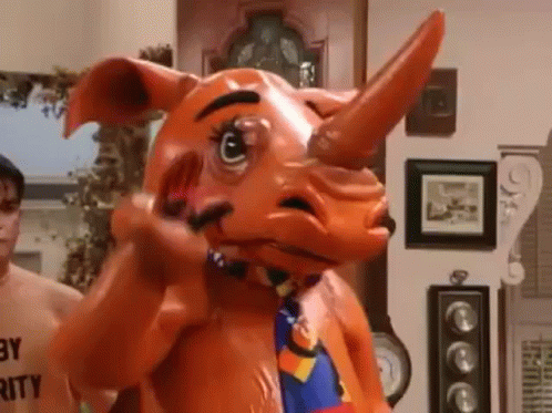A Man Is Standing Next To A Rhino Mascot Costume In A Living Room . GIF