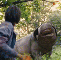 A Man Is Standing Next To A Stuffed Animal That Looks Like A Pig With Its Mouth Open . GIF