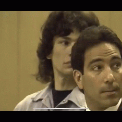 A Man Is Standing Next To A Woman In A Courtroom . GIF