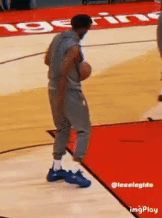 A Man Is Standing On A Basketball Court Holding A Basketball In His Hand . GIF