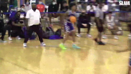 A Man Is Standing On A Basketball Court Watching A Player Shoot A Basketball . GIF