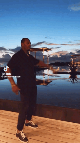 A Man Is Standing On A Dock With A Tiktok Watermark On The Bottom GIF