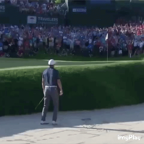 A Man Is Standing On A Golf Course With A Crowd Behind Him And A Sign That Says Travelers On It GIF