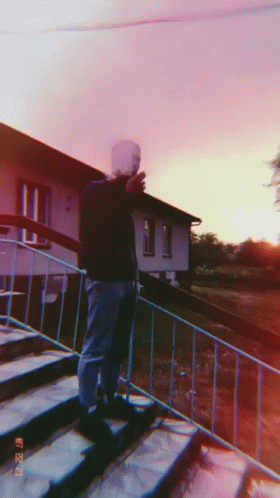 a man is standing on a set of stairs taking a picture with his phone