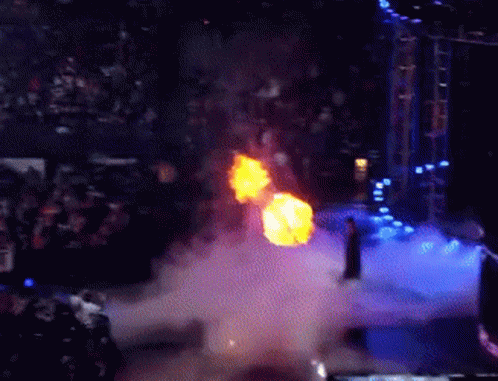 A Man Is Standing On A Stage With A Fireball Coming Out Of His Chest GIF