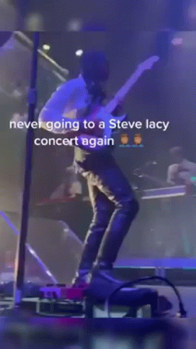 A Man Is Standing On A Stage With A Microphone And A Caption That Says Never Going To A Steve Lacy Concert Again GIF