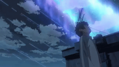 A Man Is Standing On The Roof Of A Building Looking Up At The Sky . GIF
