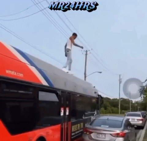 A Man Is Standing On The Roof Of A Bus With Mr24hrs Written On The Bottom GIF