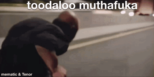 A Man Is Standing On The Side Of The Road With The Words Toodaloo Muthafuka Above Him . GIF