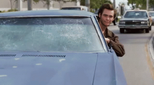 A Man Is Sticking His Finger Out Of A Car Window GIF