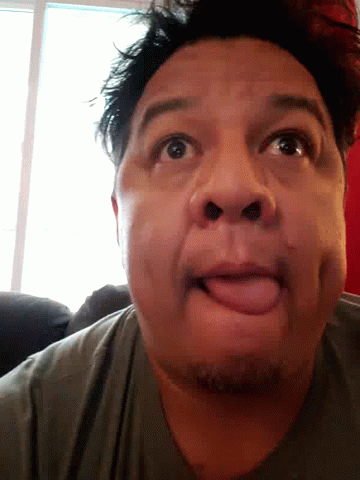 A Man Is Sticking His Tongue Out And Making A Funny Face GIF
