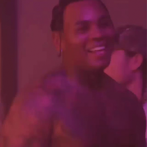 A Man Is Sticking His Tongue Out In Front Of A Purple Background . GIF