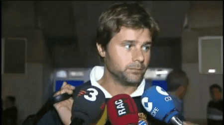 A Man Is Surrounded By Microphones Including One That Says Rac On It GIF