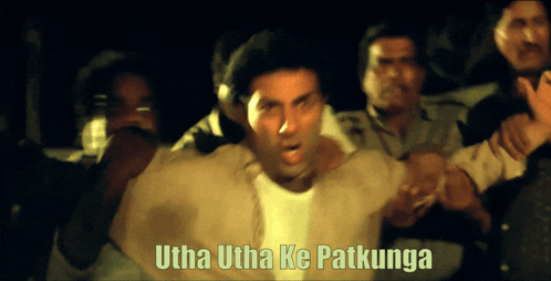 A Man Is Surrounded By People With The Words Utha Utha Ke Patkunga Written Above Him GIF
