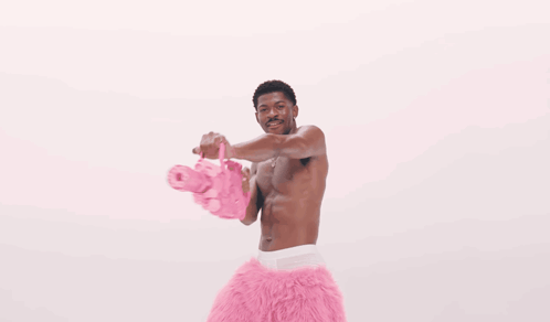 A Man Is Surrounded By Pink Hearts That Are Floating Around Him GIF
