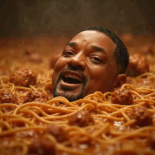 A Man Is Surrounded By Spaghetti And Meatballs GIF
