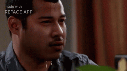 A Man Is Sweating While Sitting At A Table And Looking At The Camera . GIF