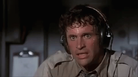 A Man Is Sweating While Wearing Headphones And Making A Funny Face . GIF