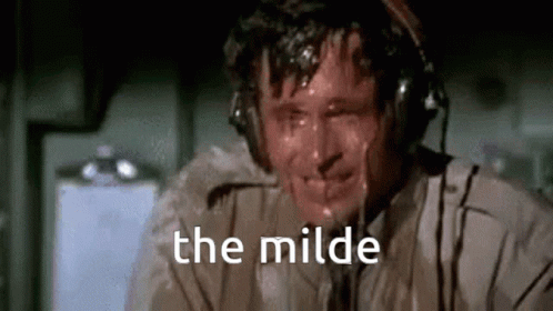 A Man Is Sweating While Wearing Headphones And The Words `` The Milde '' Are Written On The Screen . GIF