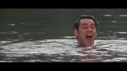 A Man Is Swimming In A Lake With His Mouth Open And His Eyes Closed . GIF
