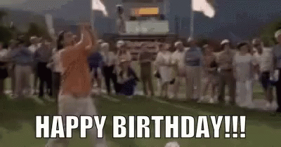 A Man Is Swinging A Golf Club On A Golf Course While A Crowd Of People Applaud . GIF