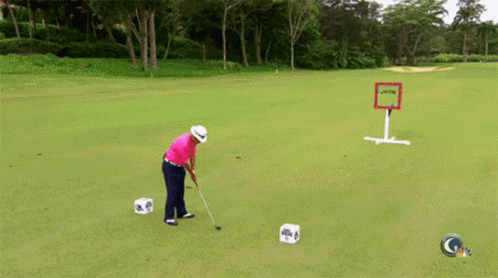 A Man Is Swinging A Golf Club On A Green With A Sign In The Background That Says Gtv GIF