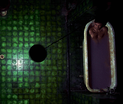 A Man Is Taking A Bath In A Bathtub With Purple Liquid GIF