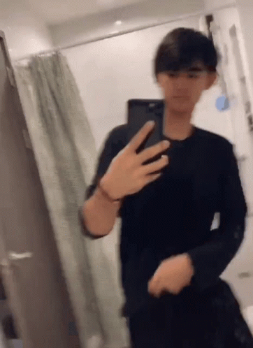 A Man Is Taking A Picture Of Himself In A Bathroom With His Phone . GIF