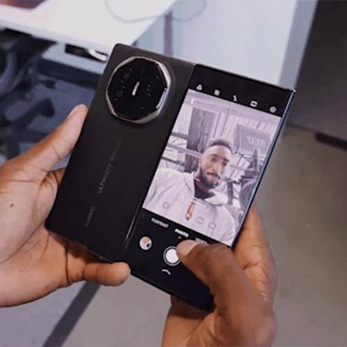 A Man Is Taking A Picture Of Himself With A Phone That Says Huawei On It GIF