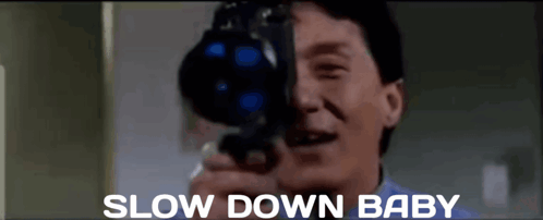 A Man Is Taking A Picture With A Camera And The Words Slow Down Baby Are Below Him GIF