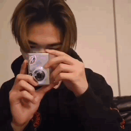 A Man Is Taking A Picture With A Camera . GIF