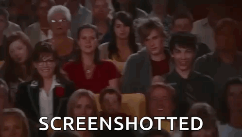 A Man Is Taking A Screenshot Of A Crowd Of People In A Theatre . GIF