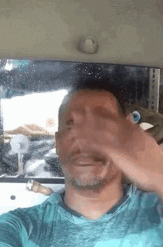 A Man Is Taking A Selfie In A Car . GIF