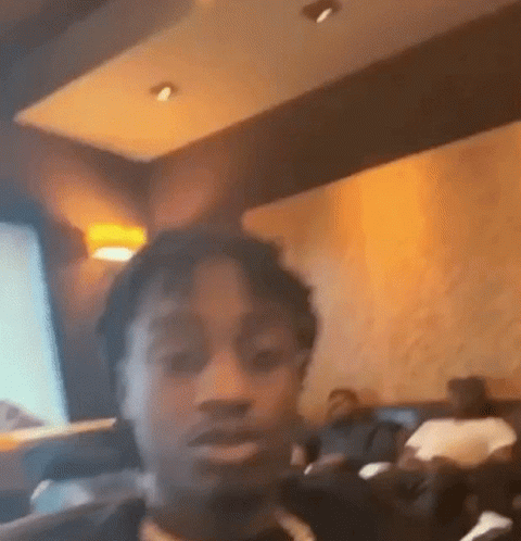 A Man Is Taking A Selfie In A Restaurant While Sitting At A Table . GIF