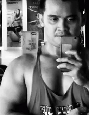 A Man Is Taking A Selfie In Front Of A Mirror . GIF