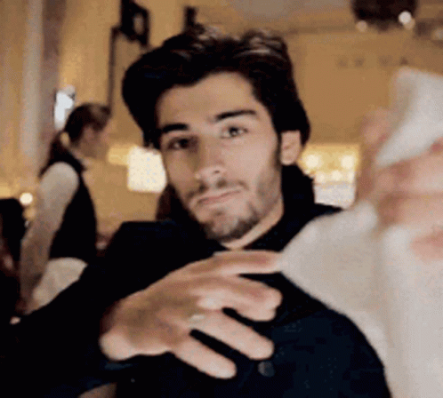 A Man Is Taking A Selfie With His Cell Phone . GIF