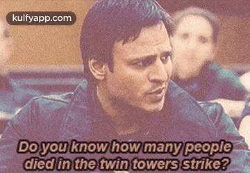 A Man Is Talking About How Many People Died In A Twin Towers Strike . GIF