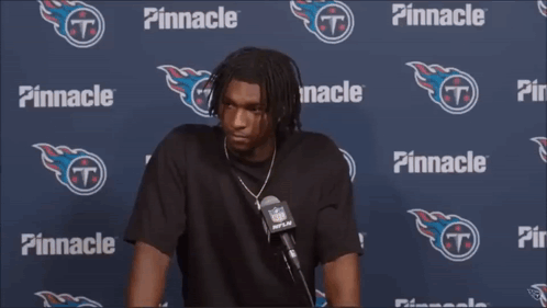 a man is talking into a microphone in front of a pinnacle banner