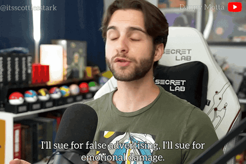 A Man Is Talking Into A Microphone While Wearing A Green Shirt That Says Secret Lab GIF