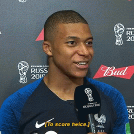 A Man Is Talking Into A Microphone While Wearing A Shirt That Says Russ GIF