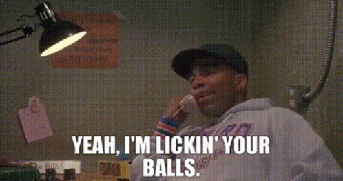 a man is talking on a cell phone and saying `` yeah , i 'm licking your balls ''