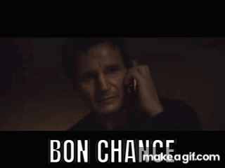 A Man Is Talking On A Cell Phone In A Dark Room With The Words Bon Chance Written On The Bottom . GIF