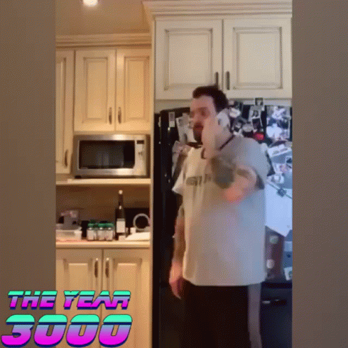 a man is talking on a cell phone in a kitchen with the year 3000 on the bottom